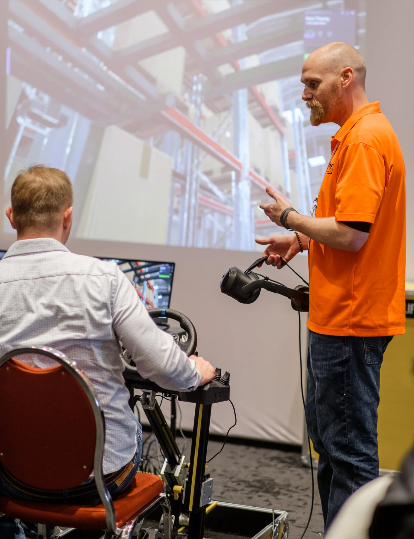 Explaining the simulator controls with the virtual warehouse on screen.